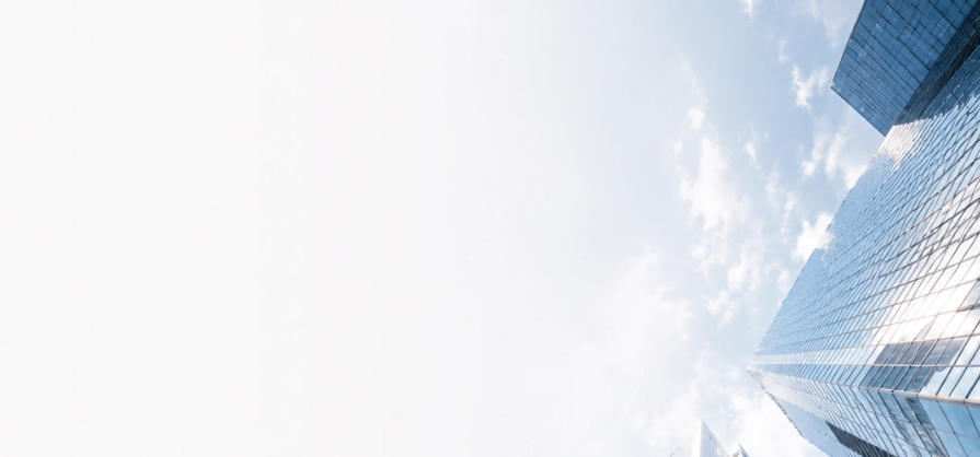 Modern glass office towers viewed from below against a bright sky